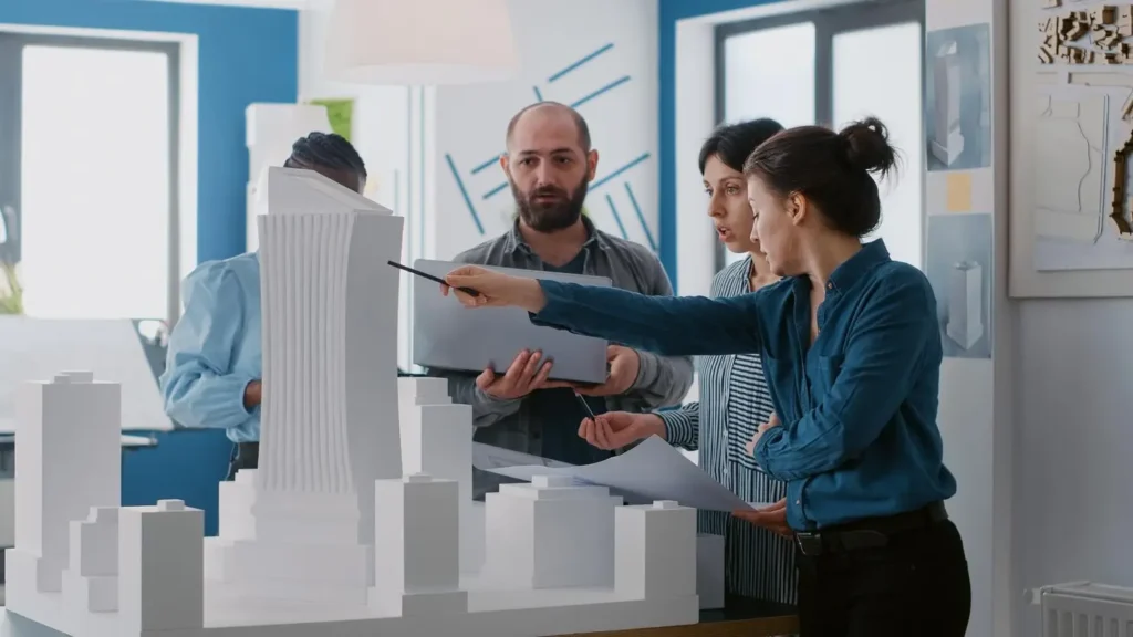 multi ethnic people working with laptop tablet building model architecture project coworkers doing teamwork design maquette construction layout with blueprints 482257 38871